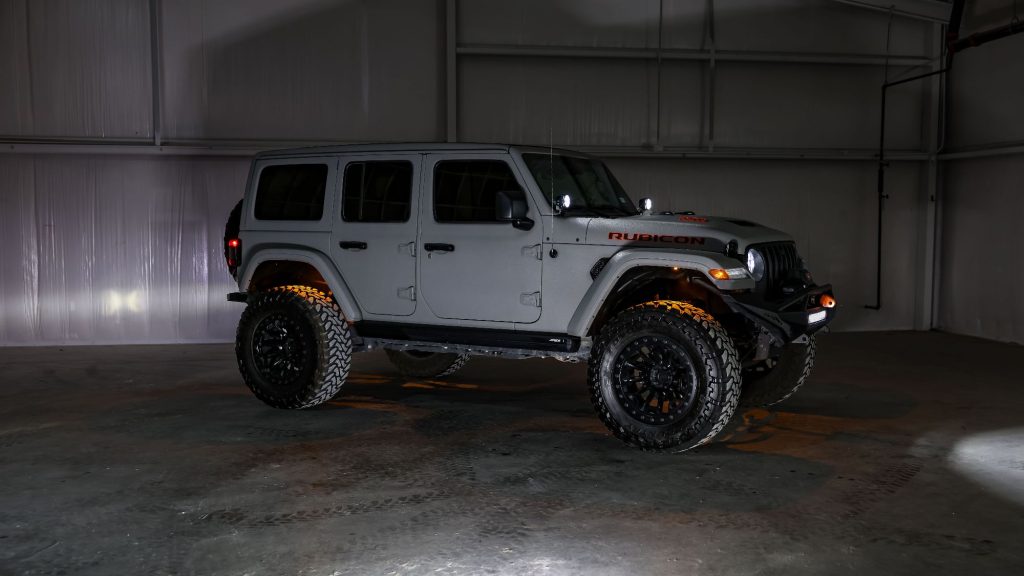 Custom Jeep Rubicon featuring lifted suspension, off-road wheels and tires, auxiliary lighting, and aftermarket accessories installed by Apex Custom Innovations