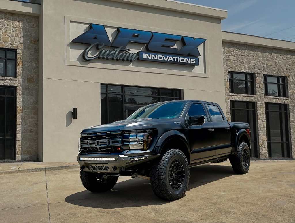 Ford Raptor R custom build in front of Apex Custom Innovations Dallas location featuring Vossen wheels, Nitto tires, ADD Stealth Fighter bumpers, and Rigid LED lighting