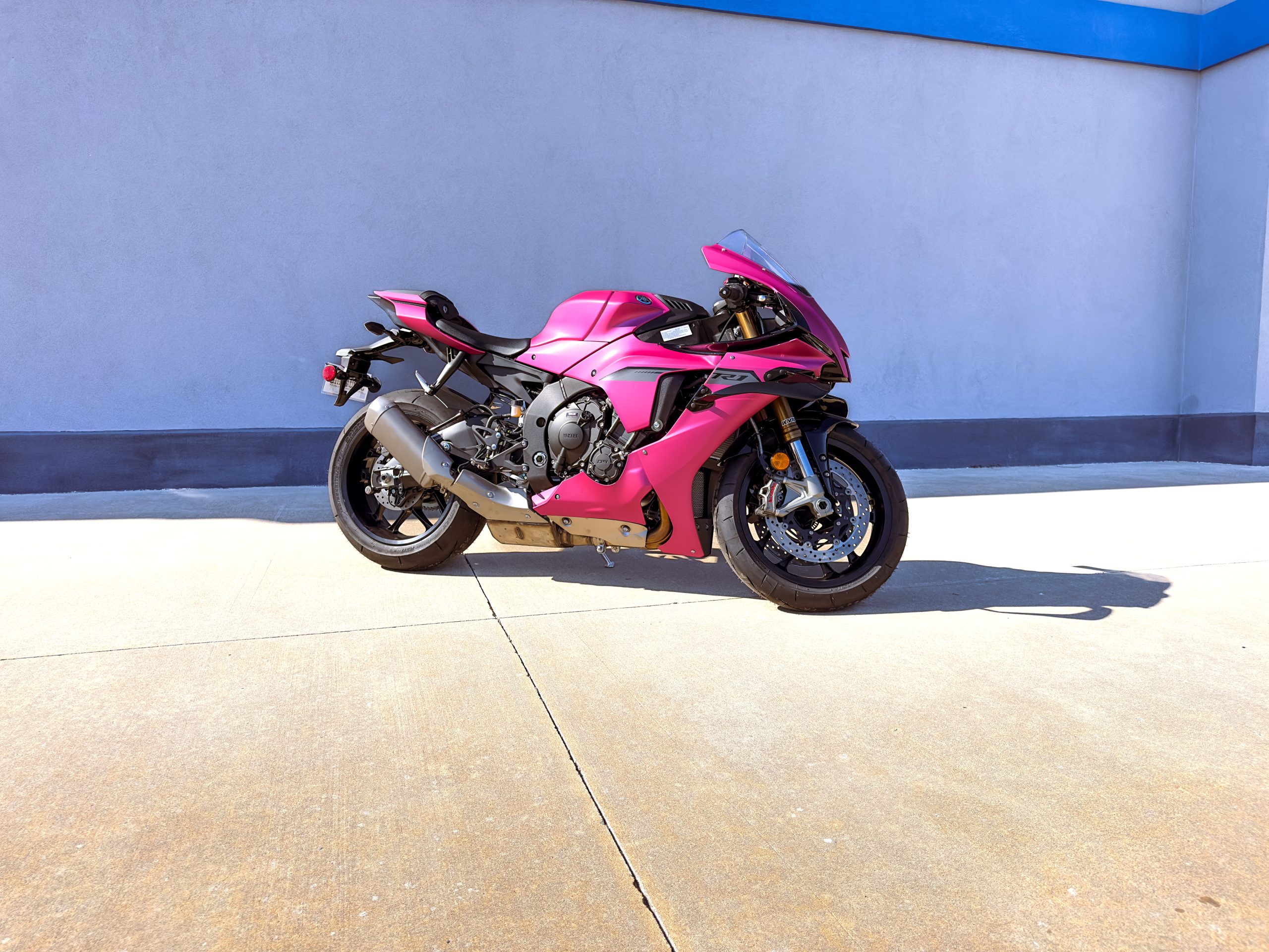 Yamaha R1 motorcycle shown in side profile with metallic pink vinyl wrap installed by Apex Custom Innovations