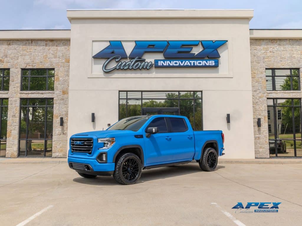 2022 GMC Sierra 1500 with Voodoo Blue Apex Armor exterior, satin black accents, TIS wheels, and Toyo tires outside Apex Custom Innovations